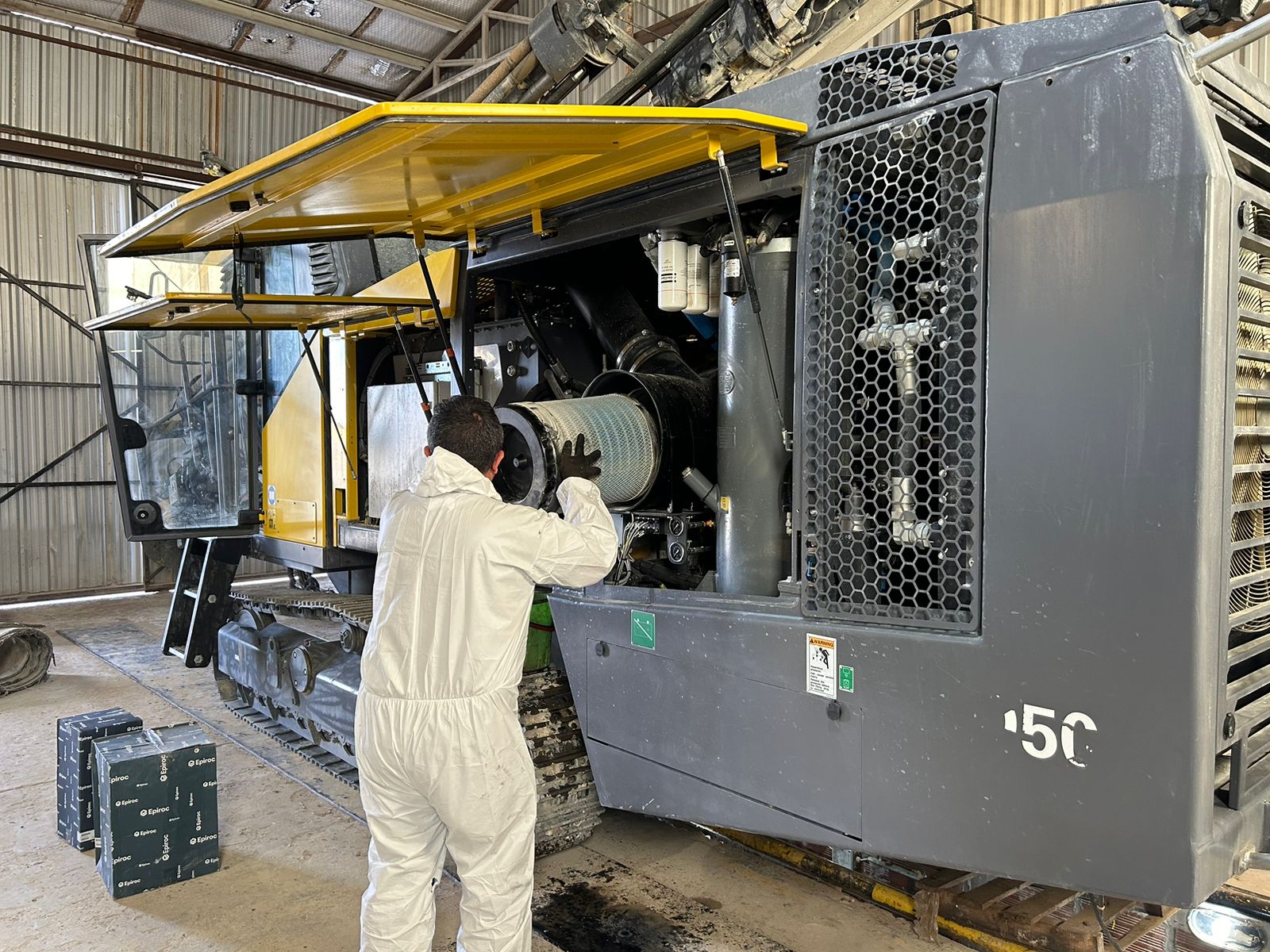 Mining technician verifying heavy equipment replacement parts with serial number and part identification before repair.