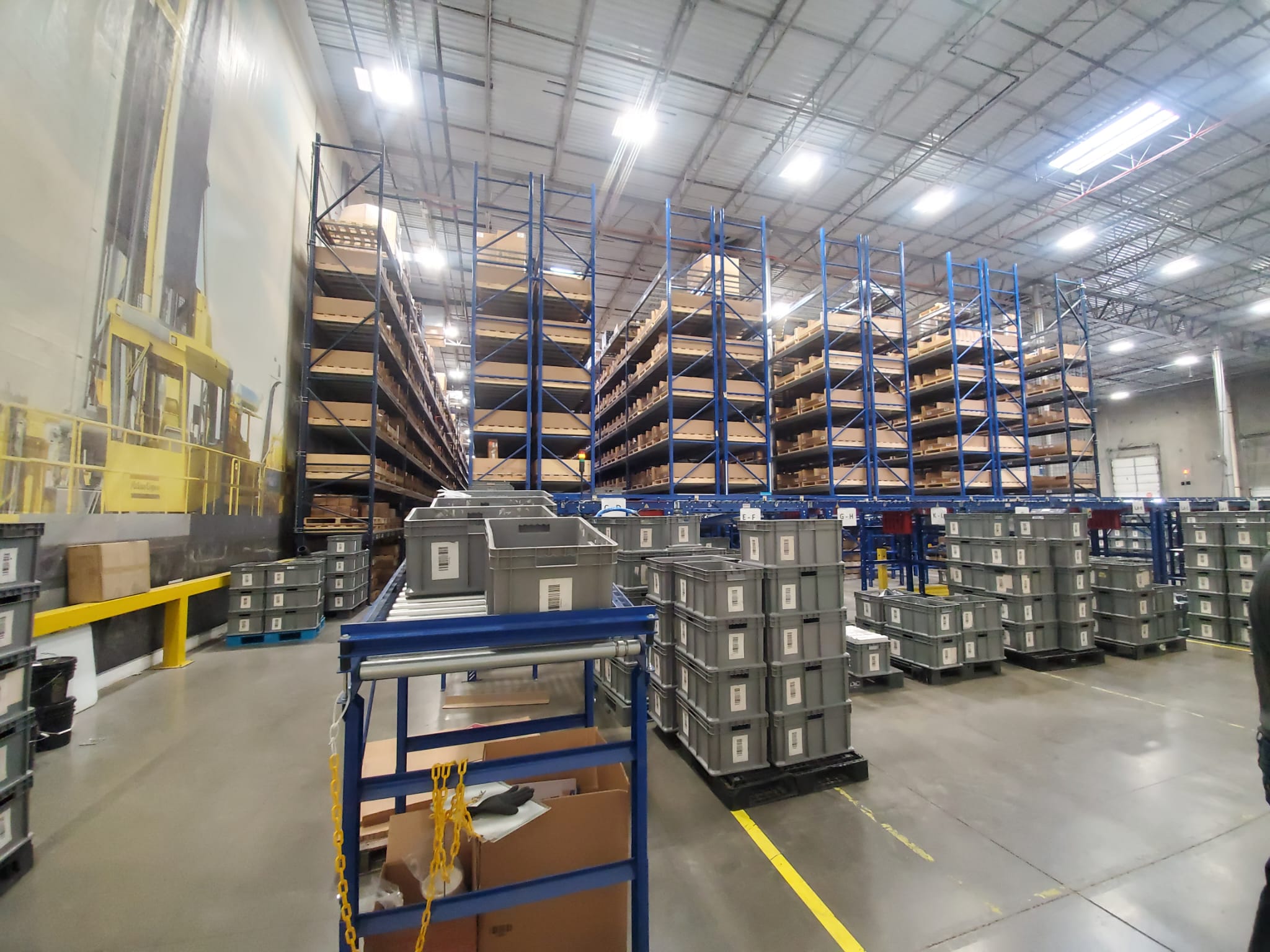 Heavy equipment parts supplier reviewing mining machinery components and order documentation at a warehouse facility in Miami